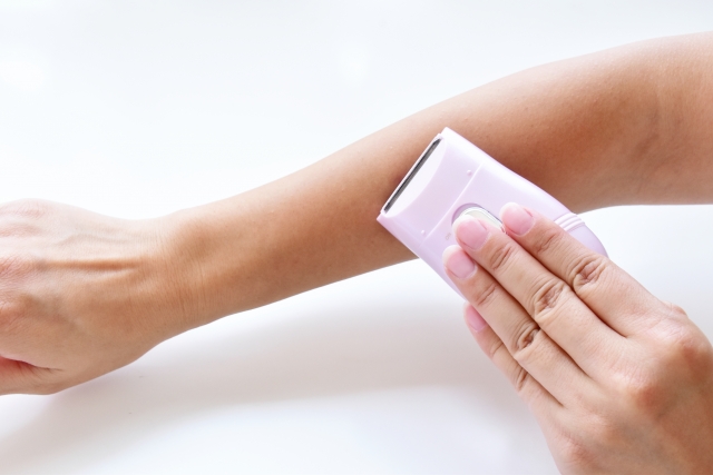 腕をシェービングする女性